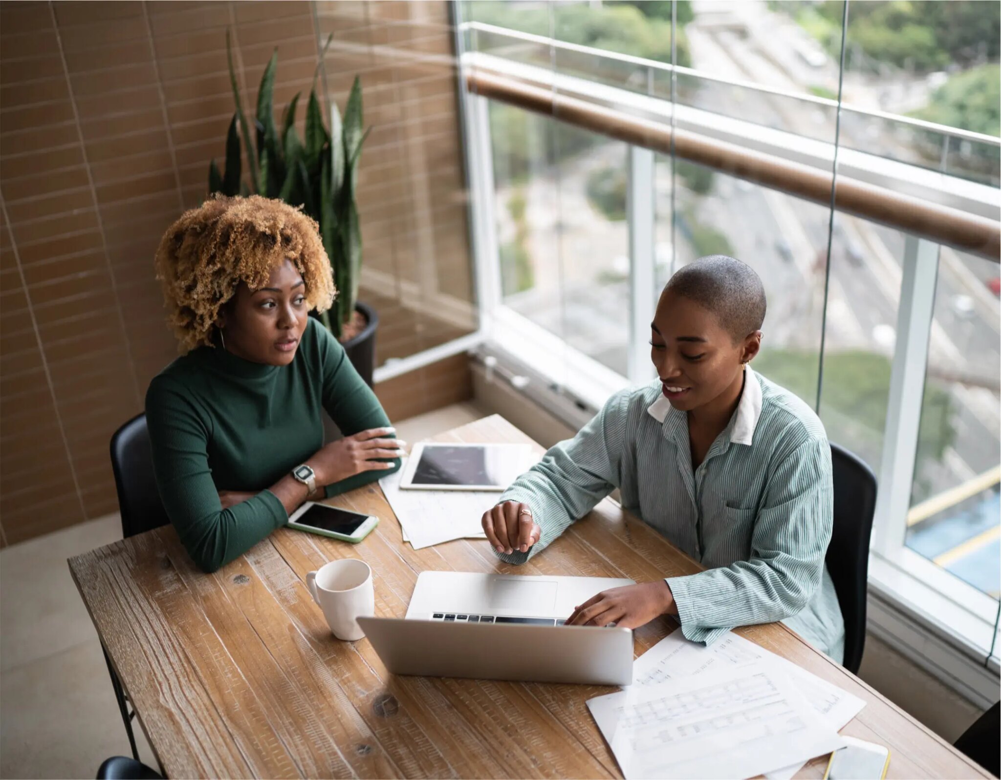 Two women working at a desk together.