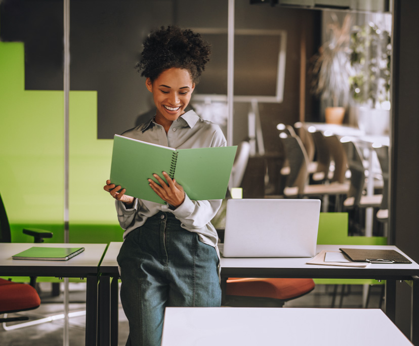Smiling woman reading document in office.