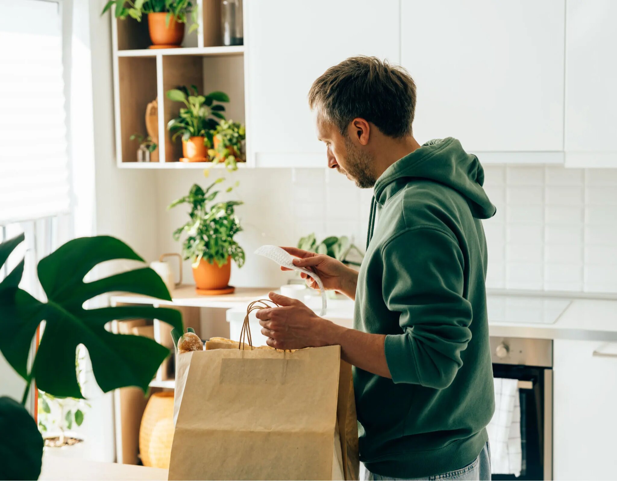 Man unpacking groceries in a kitchen.