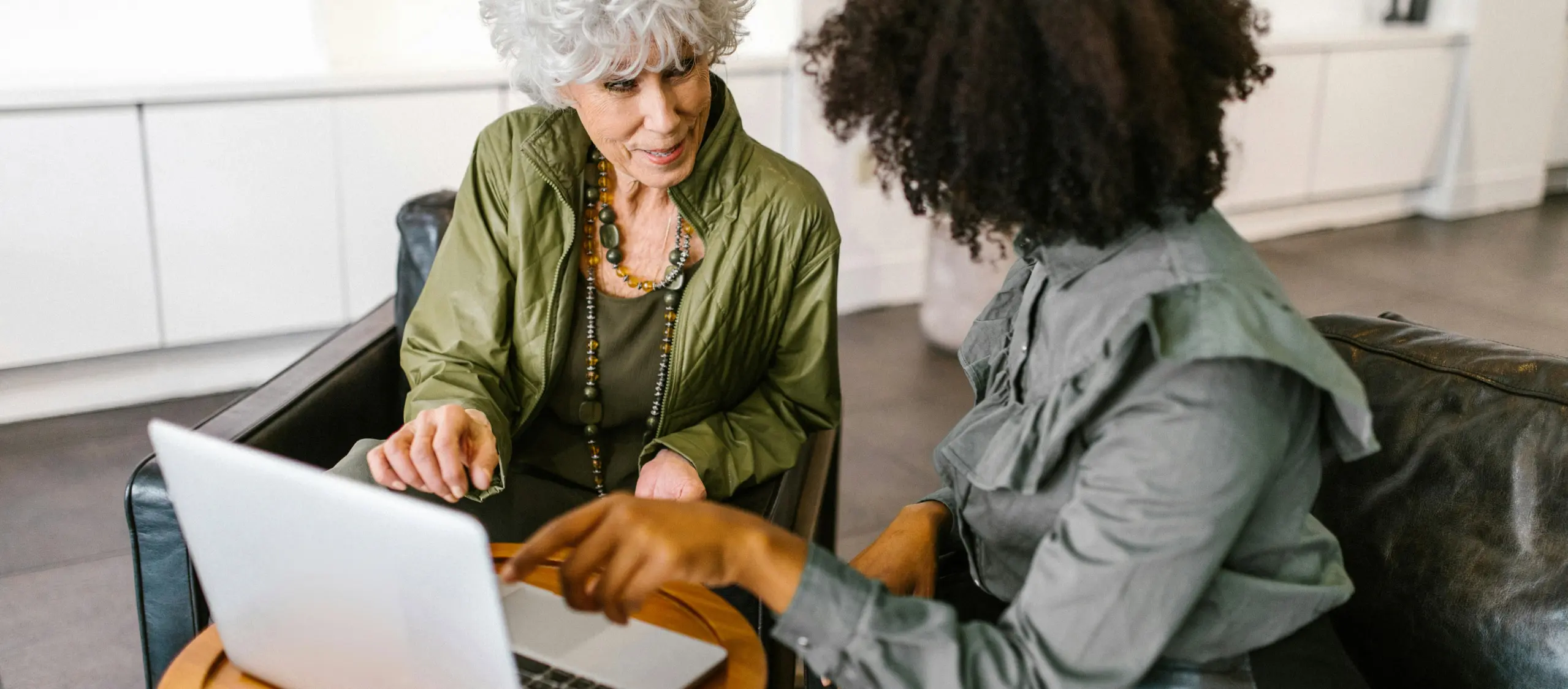 Two women discussing work on a laptop.