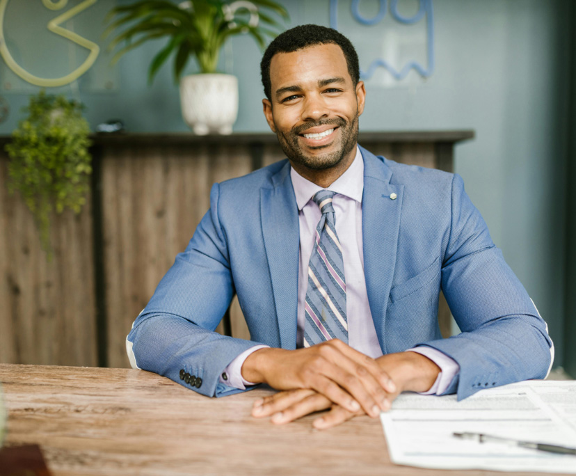 Businessman in blue suit seated at desk