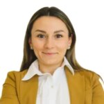 Woman smiling in a brown blazer.