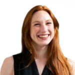 Smiling woman with red hair, white background.