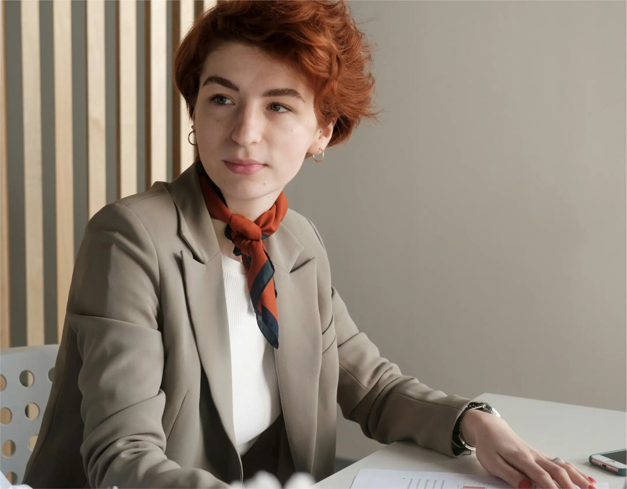 Person in blazer sitting at a table.