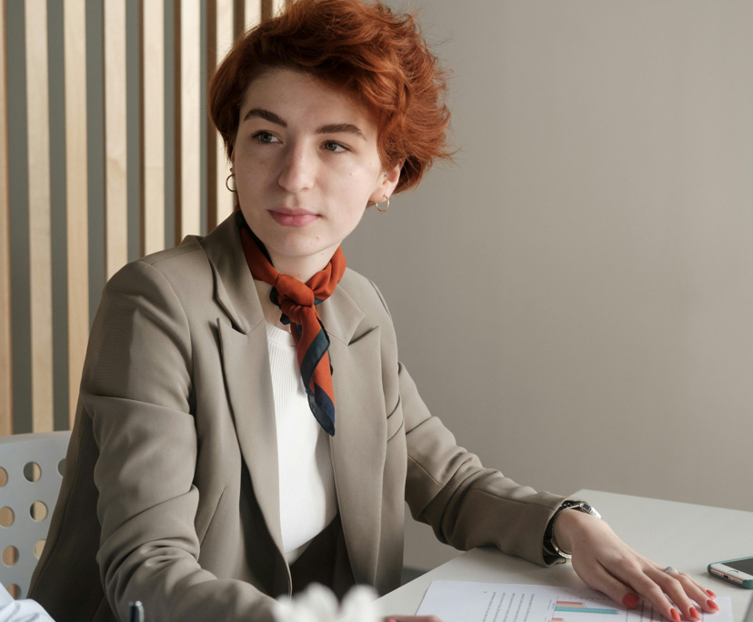 Person in suit sitting at a desk.