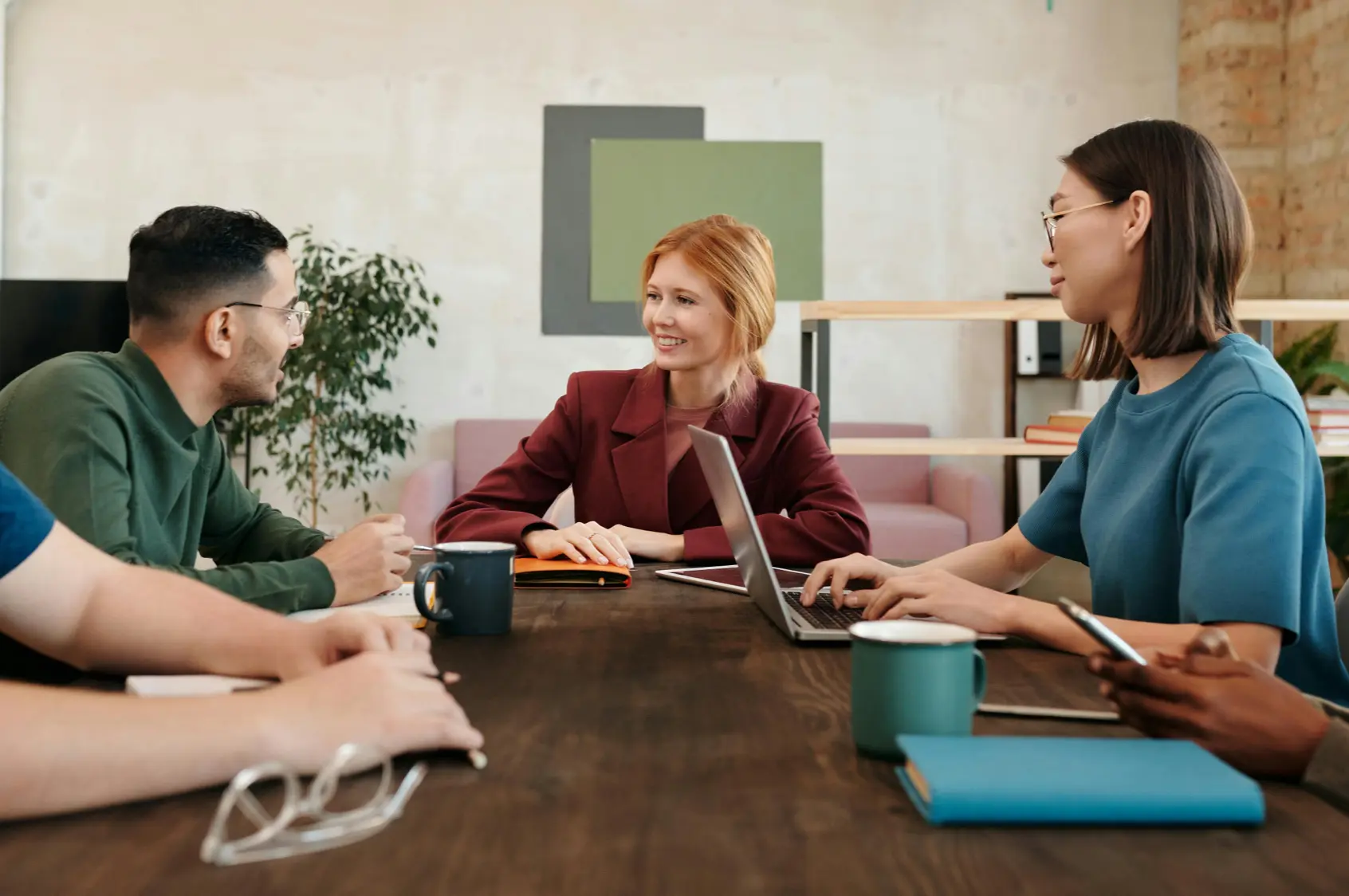 Smiling redhead leading small team meeting