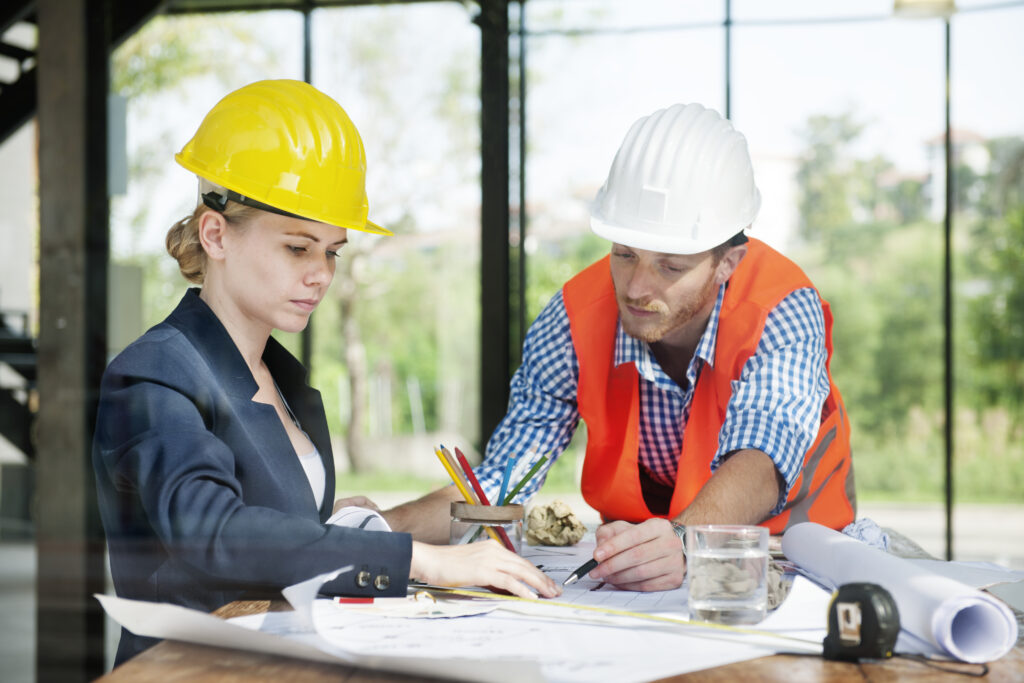 Architects reviewing construction plans at desk.