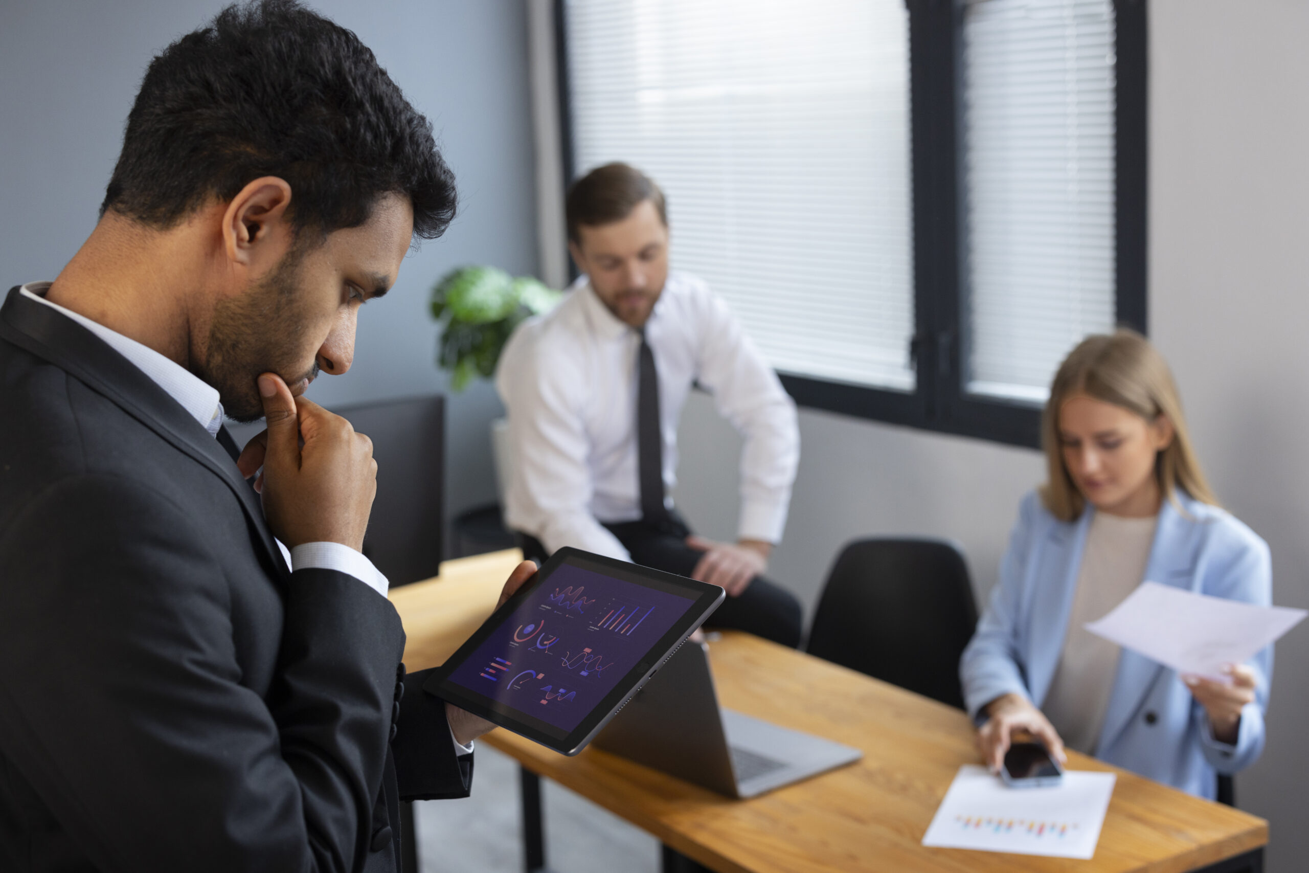 Office meeting with three focused professionals.