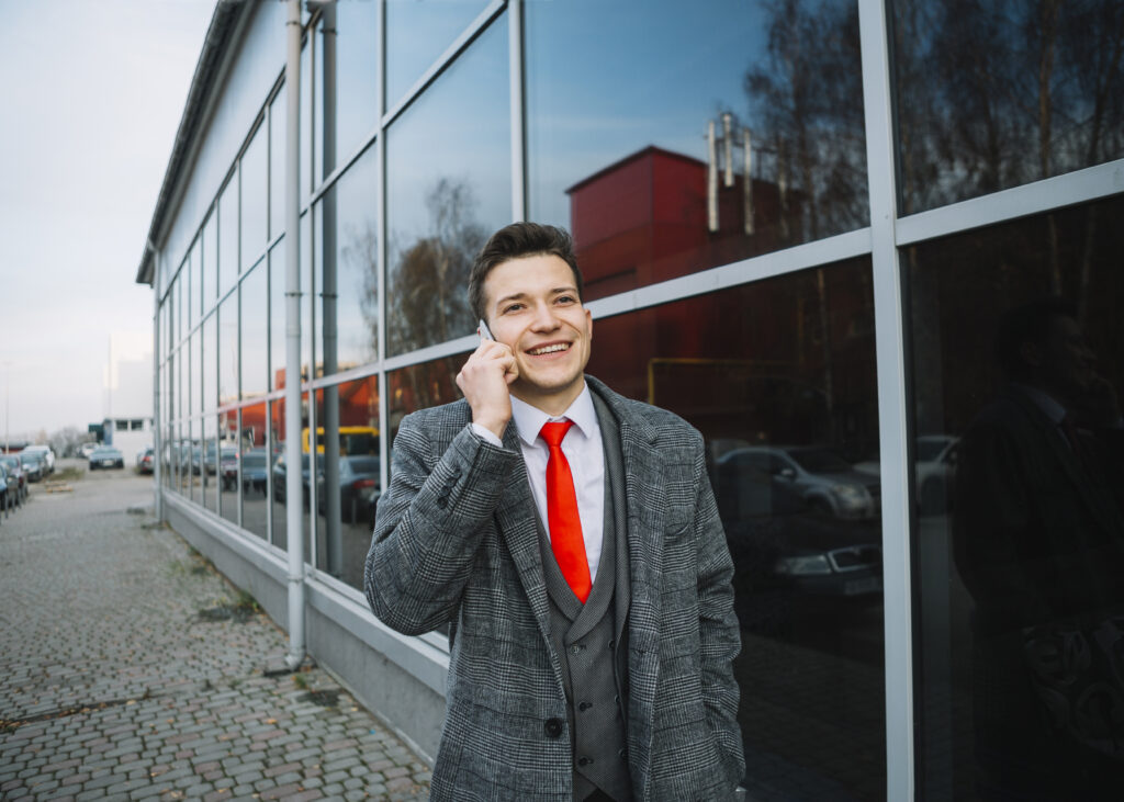 Man in suit talking on phone outside.