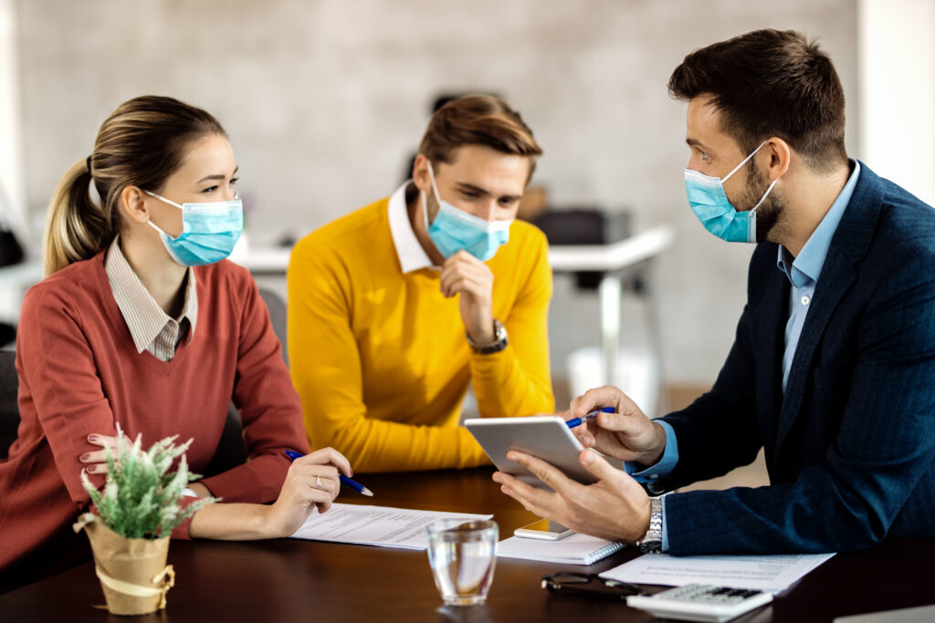 People in masks having a meeting indoors.