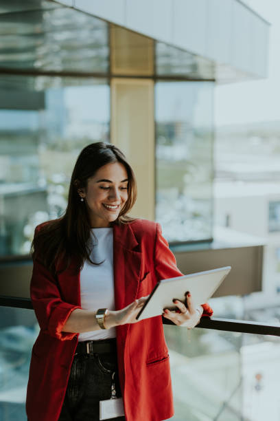 Woman in red blazer using a tablet.