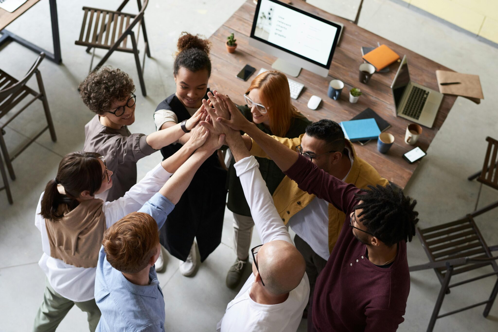 Diverse team high-fiving in a circle.