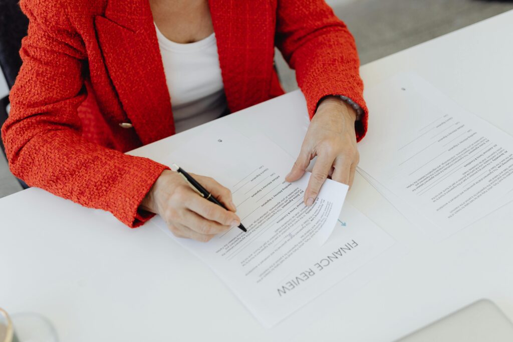 Person signing a finance review document.