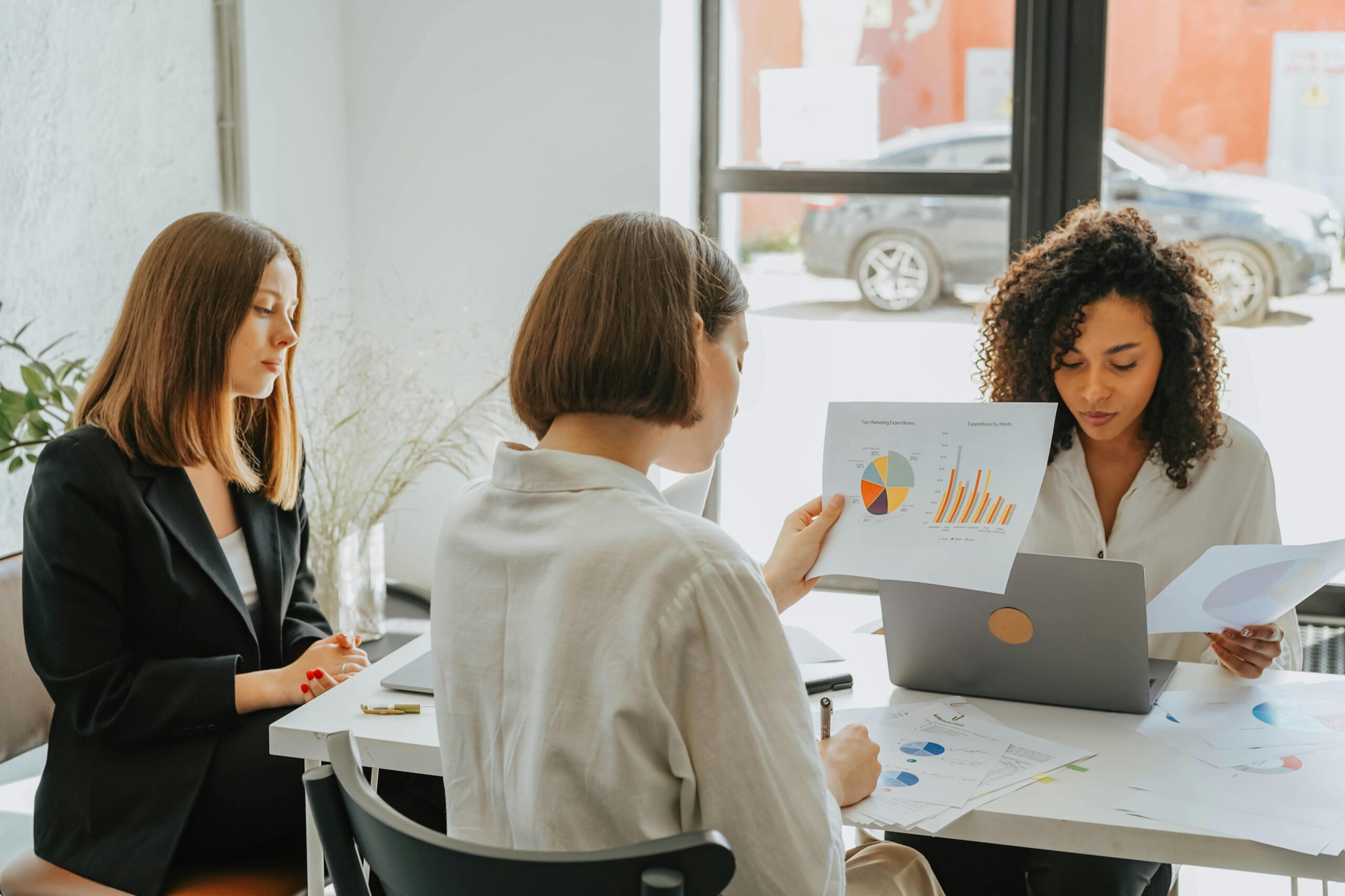 Women discussing charts in a business meeting.