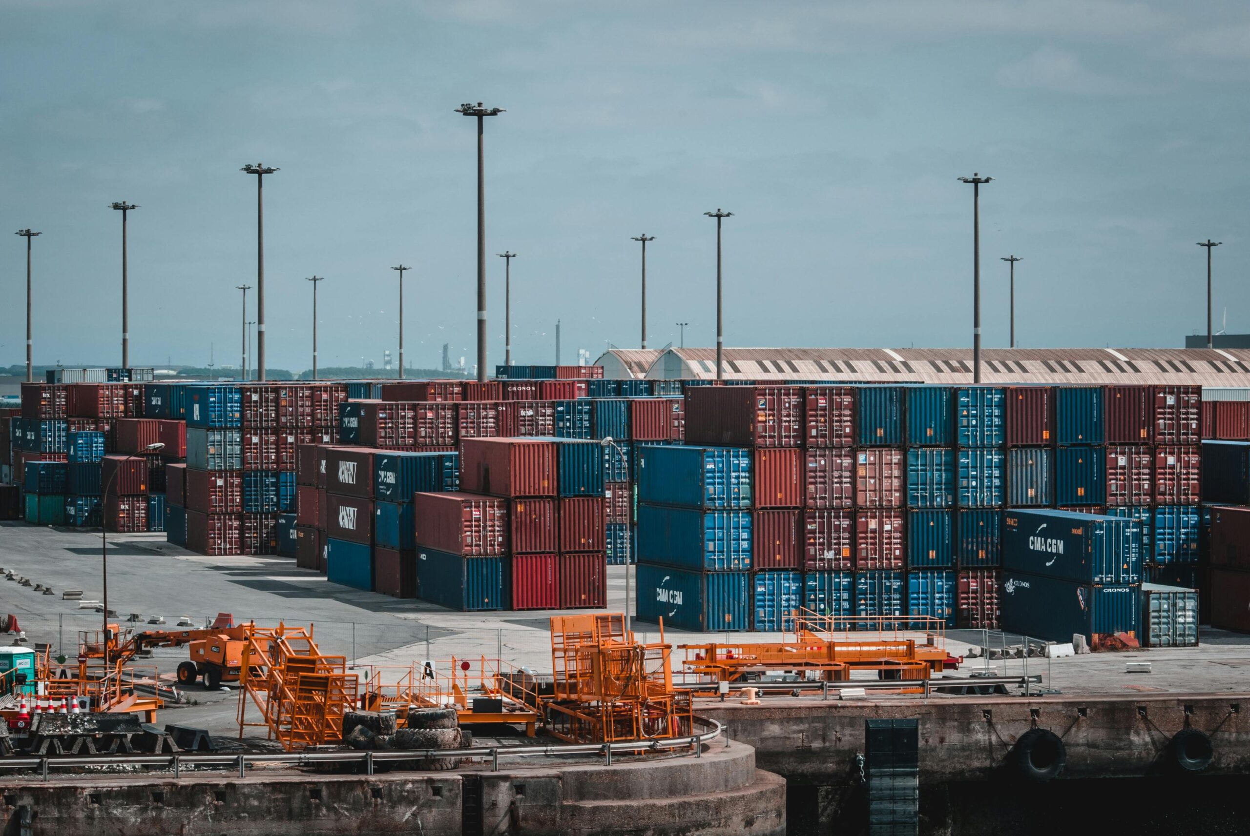 Shipping containers stacked at industrial port.