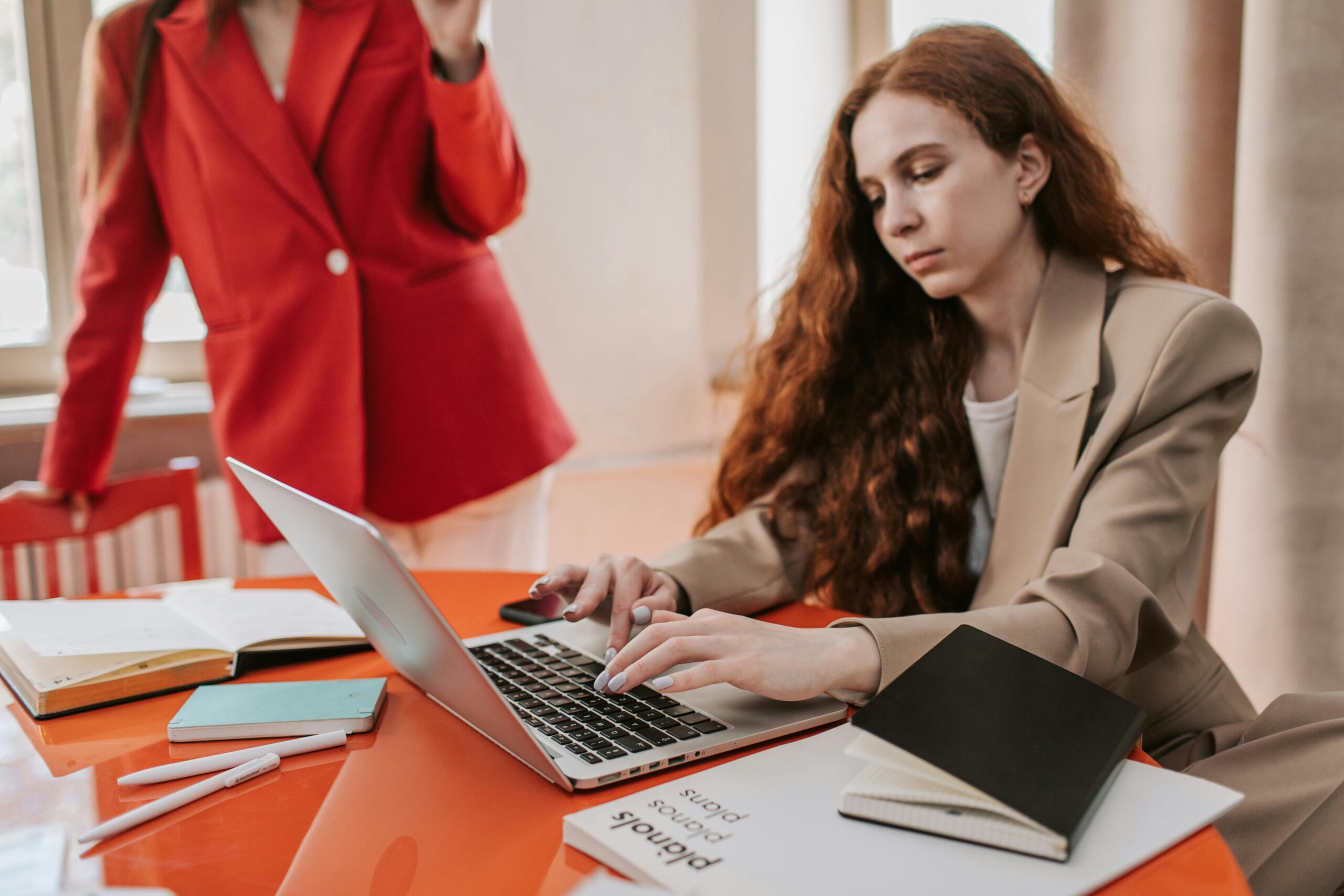 Woman working on a laptop at desk.