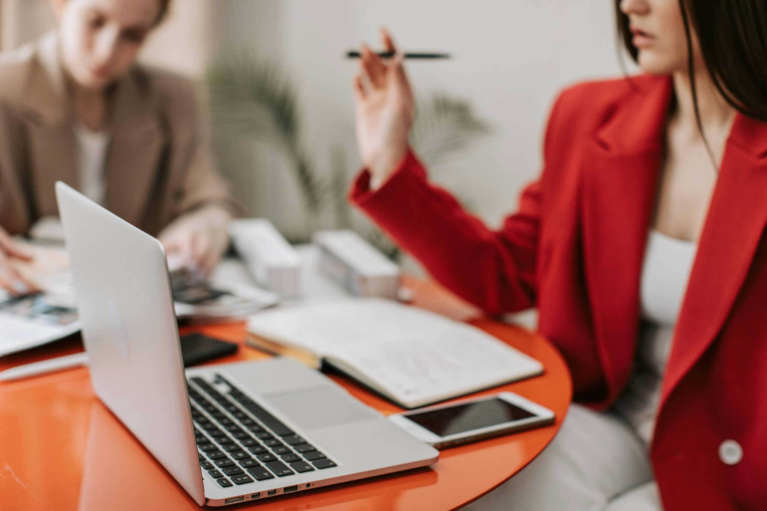 Women working at laptop and taking notes.