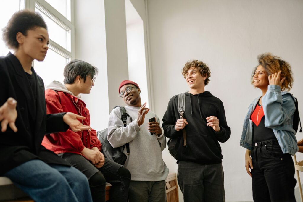 Students laughing together in sunlit hallway