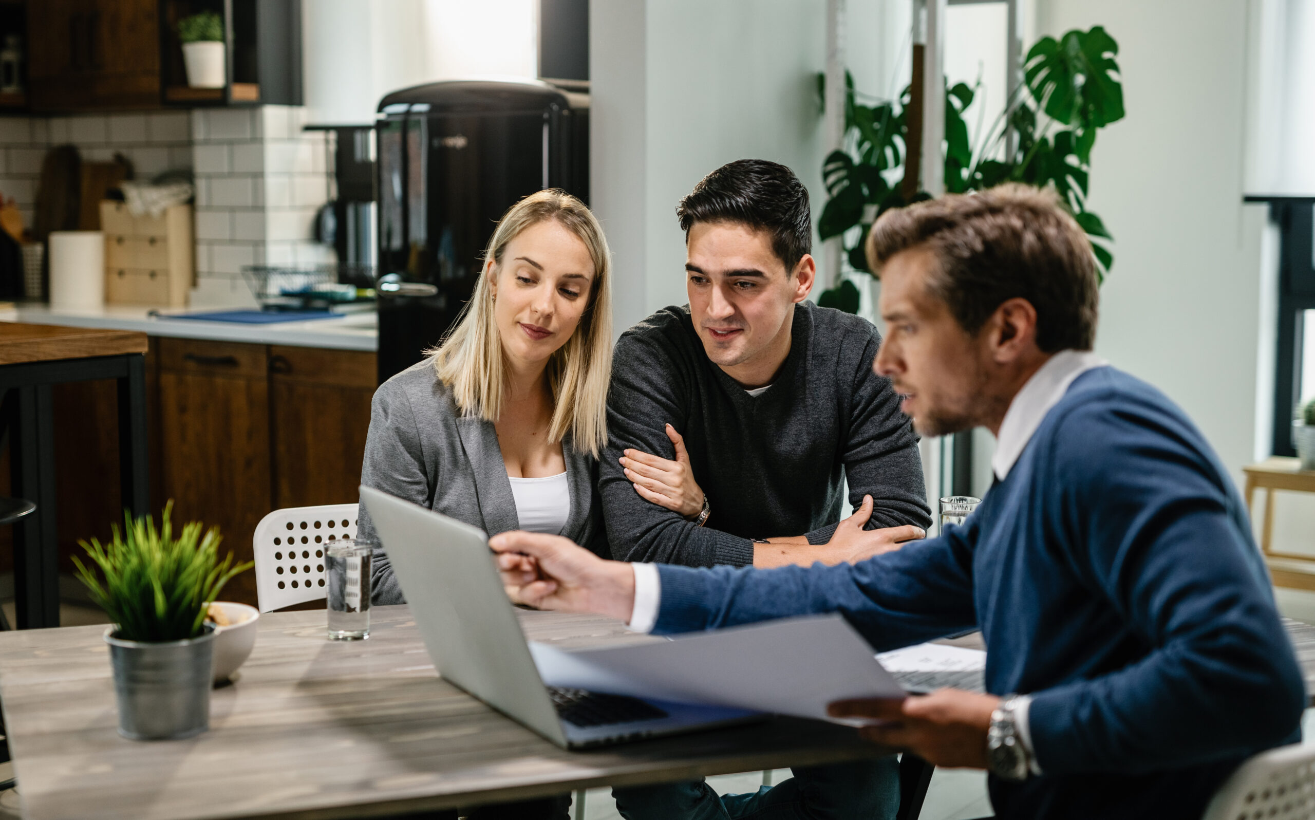 Couple consulting with professional at table.