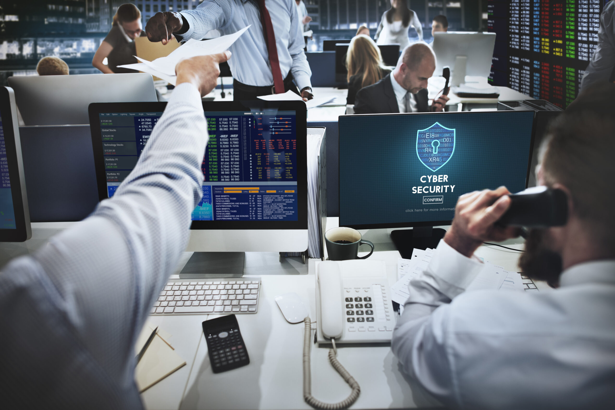 Busy trading desk with cybersecurity alert